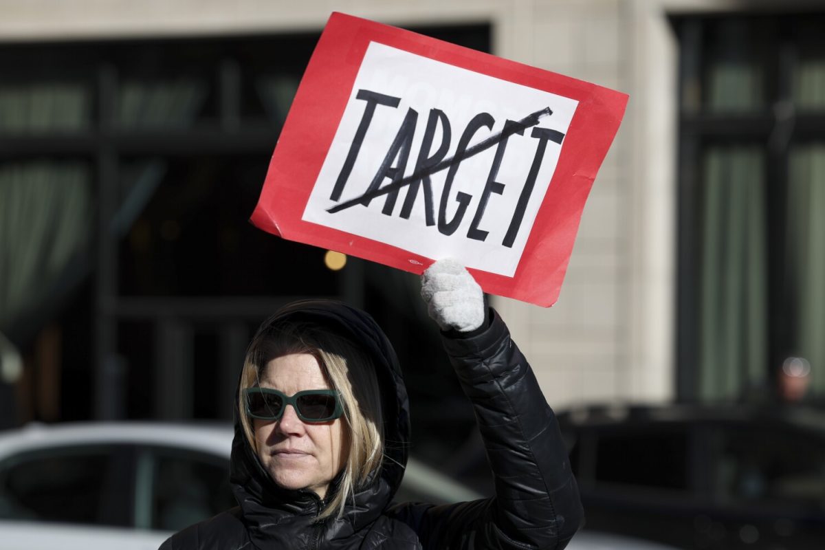 Becky Dankowski, center, of Minneapolis, who said she was a long-time customer, holds an anti-Target sign during a news conference outside Target Corporation's headquarters Thursday, Jan. 30, 2025, in Minneapolis, Minn. (AP Photo/Ellen Schmidt)